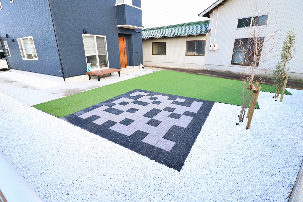 ベンチを置いた人工芝の庭でくつろげる住宅の外構事例