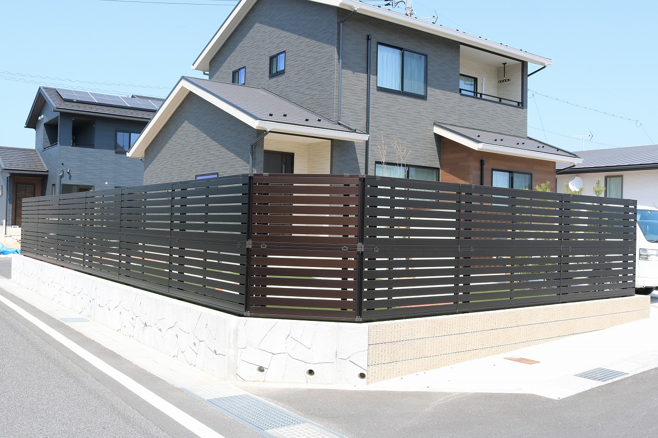 金属支柱でしっかり固定した木目調の横板目隠しフェンスの施工例