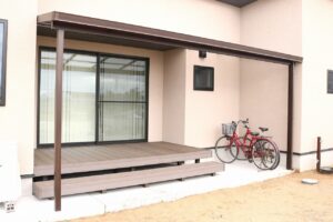屋根付きのウッドデッキに自転車を並べた住宅の施工例