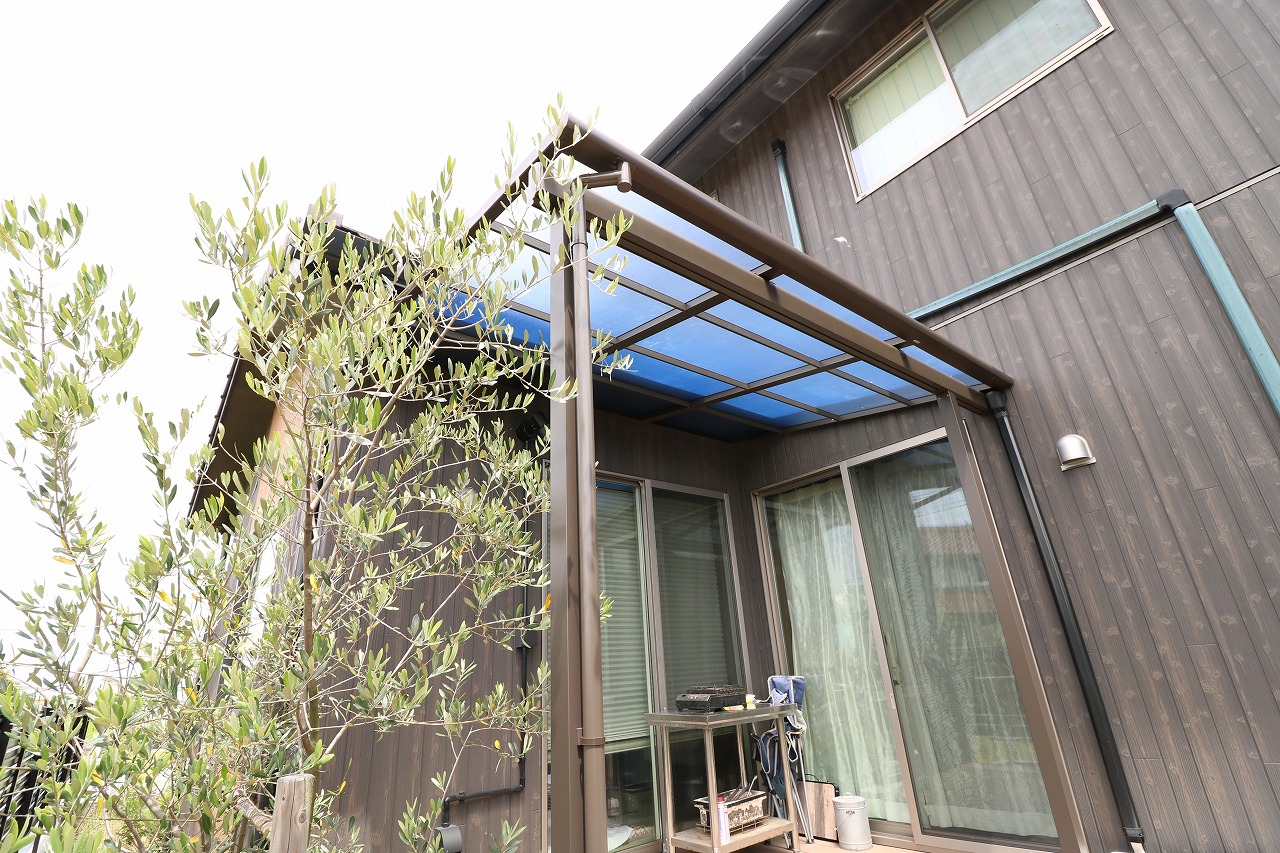 オリーブの木を添えた青みがかった屋根のテラス囲いの施工例