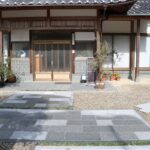 出雲で育む、経年美を大切にする外構・エクステリア 石張りのアプローチと植木鉢を配した和風住宅の玄関まわり