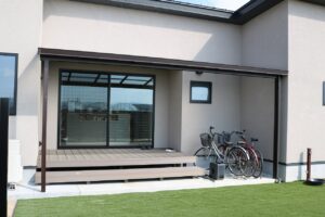 人工芝の庭に面した屋根付きウッドデッキの施工例