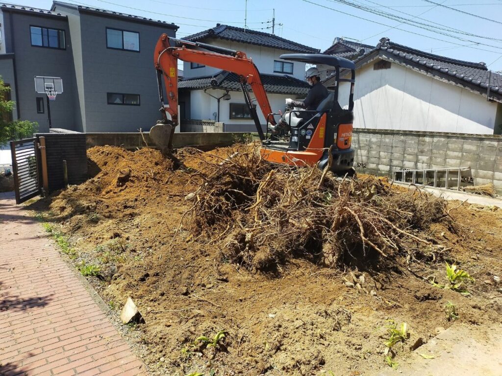 重機で庭木の根を掘り起こしている様子