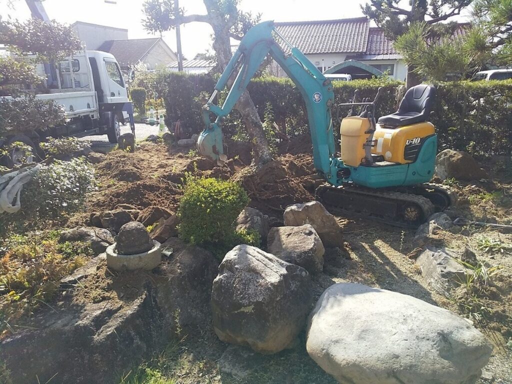 小型重機で庭木と庭石を撤去している様子